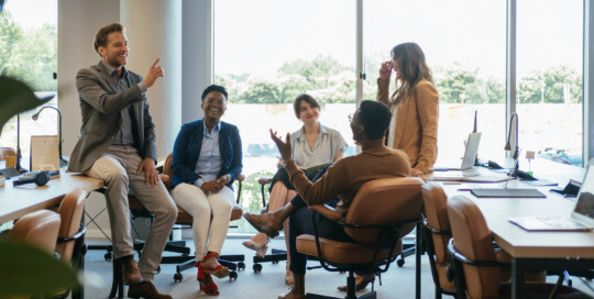 Group of Smiling Businesspeople in a Casual Meeting at their Company