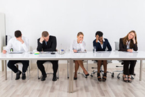 Bored and frustrated business people sitting in a row