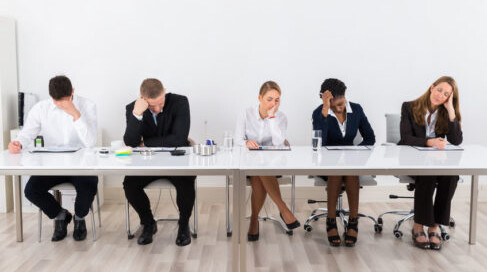 Bored and frustrated business people sitting in a row