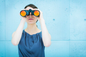 Businesswoman holding binoculars