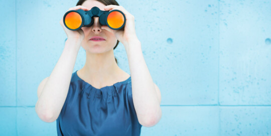 Businesswoman holding binoculars