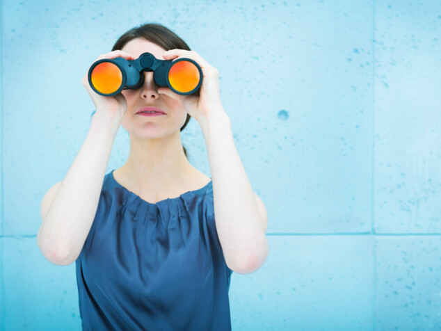 Businesswoman holding binoculars