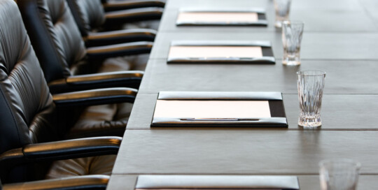 The boardroom table is set for a meeting