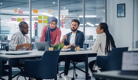 Team of four at a table sharing insights